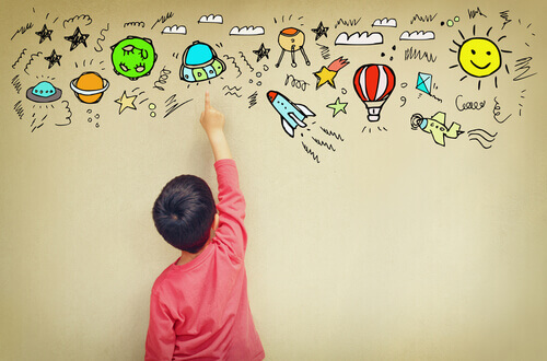Menino com síndrome de asperger desenhando na parede