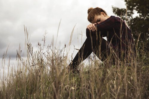 Mulher triste apoiada nos joelhos A tristeza não é o fim do mundo