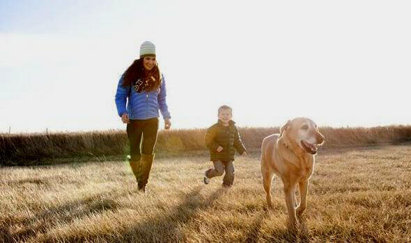 Mãe e filho passeando com seu cão