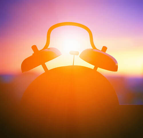 Relógio em uma janela enquanto amanhece