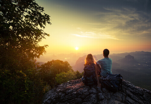 Amigos em cima da montanha observando o amanhecer