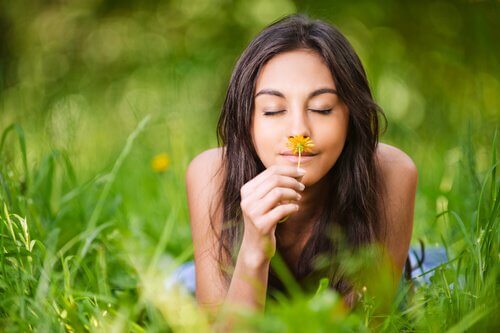 mulher-cheirando-flor-pensando-em-suas-memórias