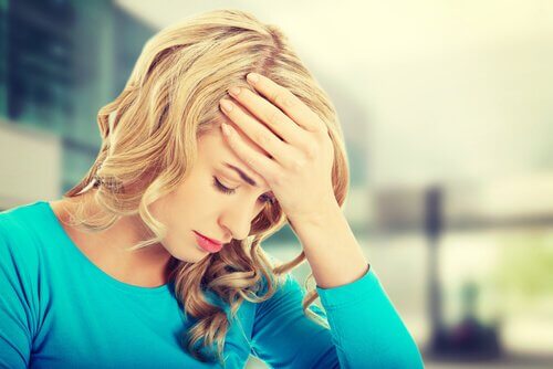 Mulher preocupada com a mão na testa