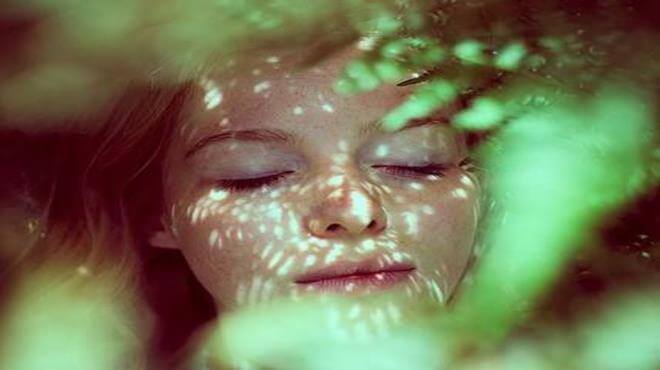 mulher-com-folhas-no-sol