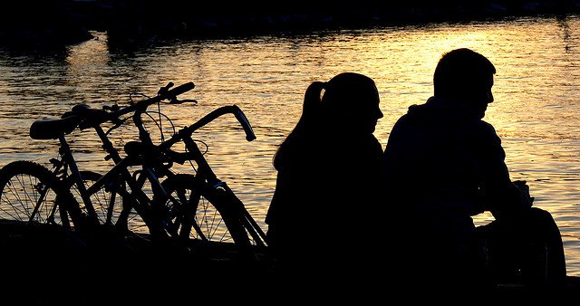 Casal conversando no rio ao lado de bicicletas É bom manter a amizade com o nosso ex?