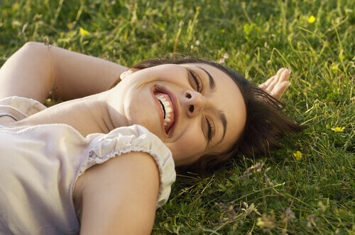 Mulher-sorrindo-deitada-na-grama