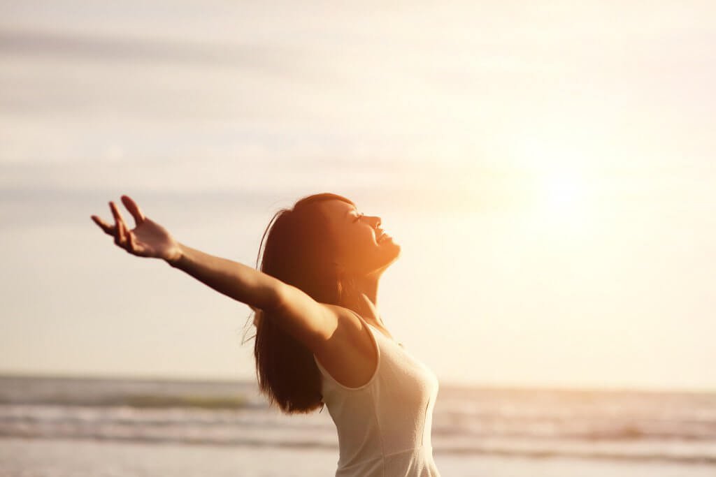 mulher_positiva_feliz_abrindo_os_bracos_para_o_sol_amanhecer