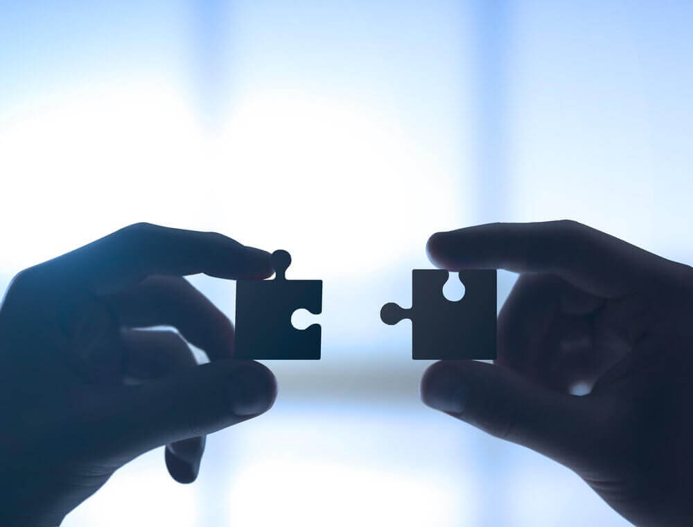 Mãos com peças de um quebra-cabeça