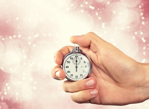 mão segurando um relógio