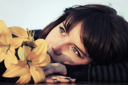 mulher-pensando-com-uma-flor 3 verdades dolorosas que esquecemos cedo demais