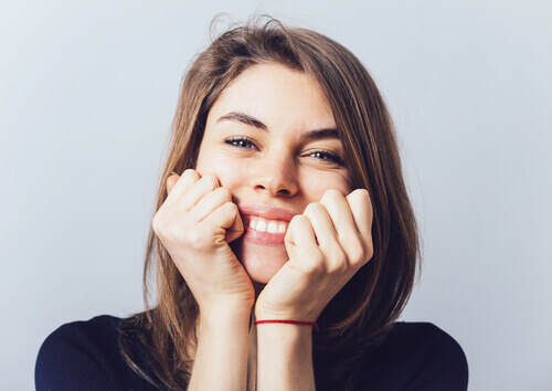 mulher-sorrindo-com-as-maos-no-rosto