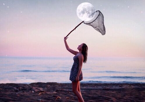 mulher-capturando-lua-na-praia