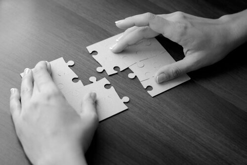 Mãos montando quebra-cabeças