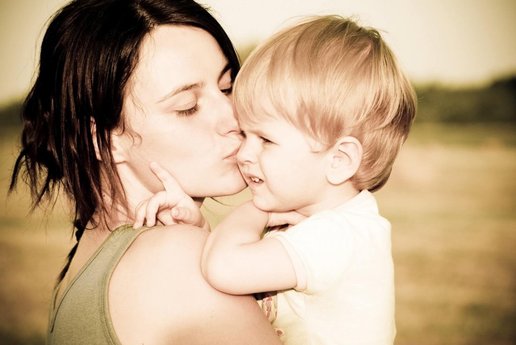 Mãe beijando seu filho pequeno