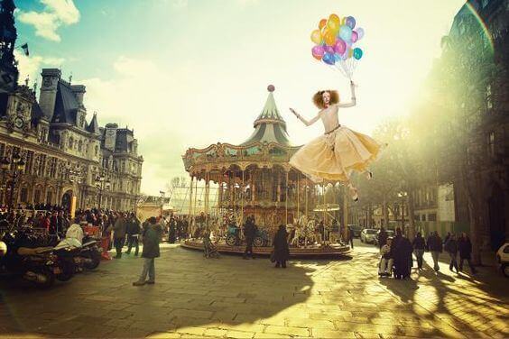 Carrossel e mulher voando segurando balões
