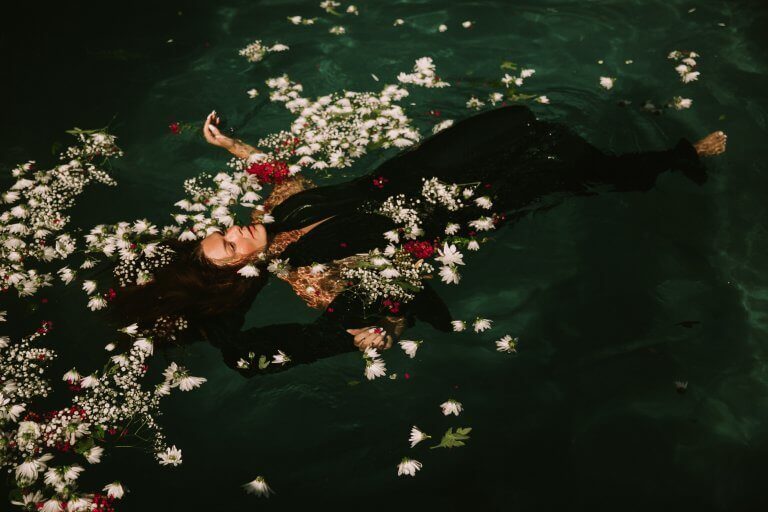Mulher flutuando em piscina de flores