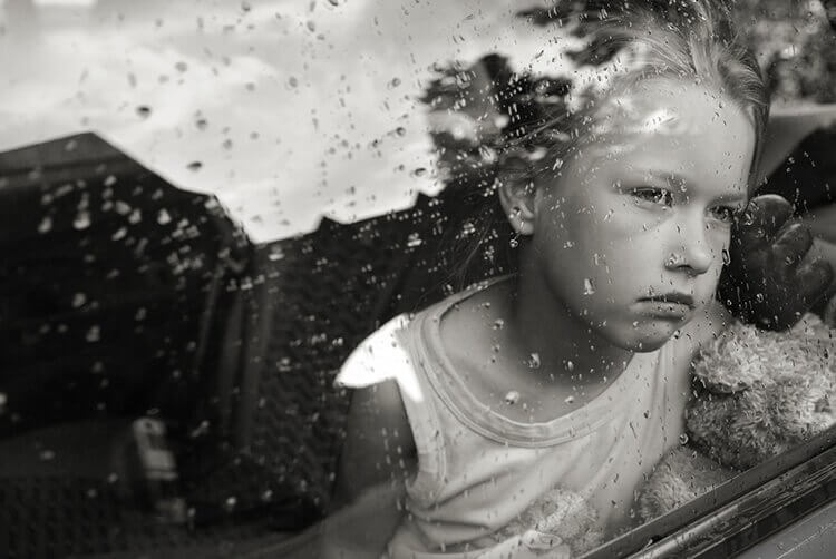Criança observando a chuva