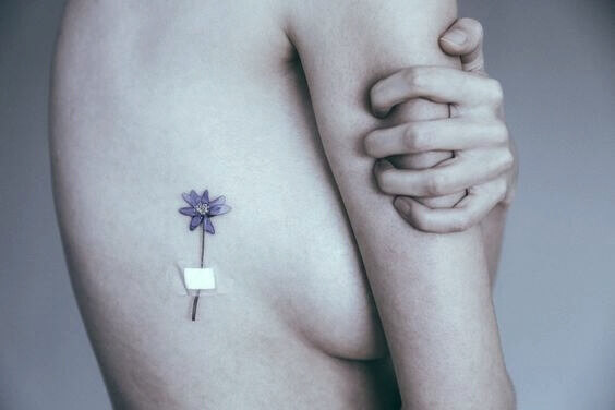 Mulher com tatuagem de flor no corpo
