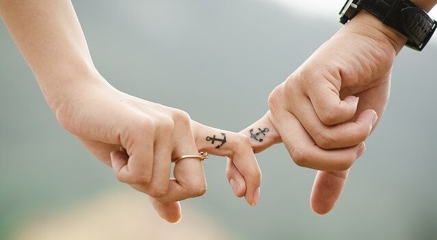Dedos entrelaçados com tatuagens