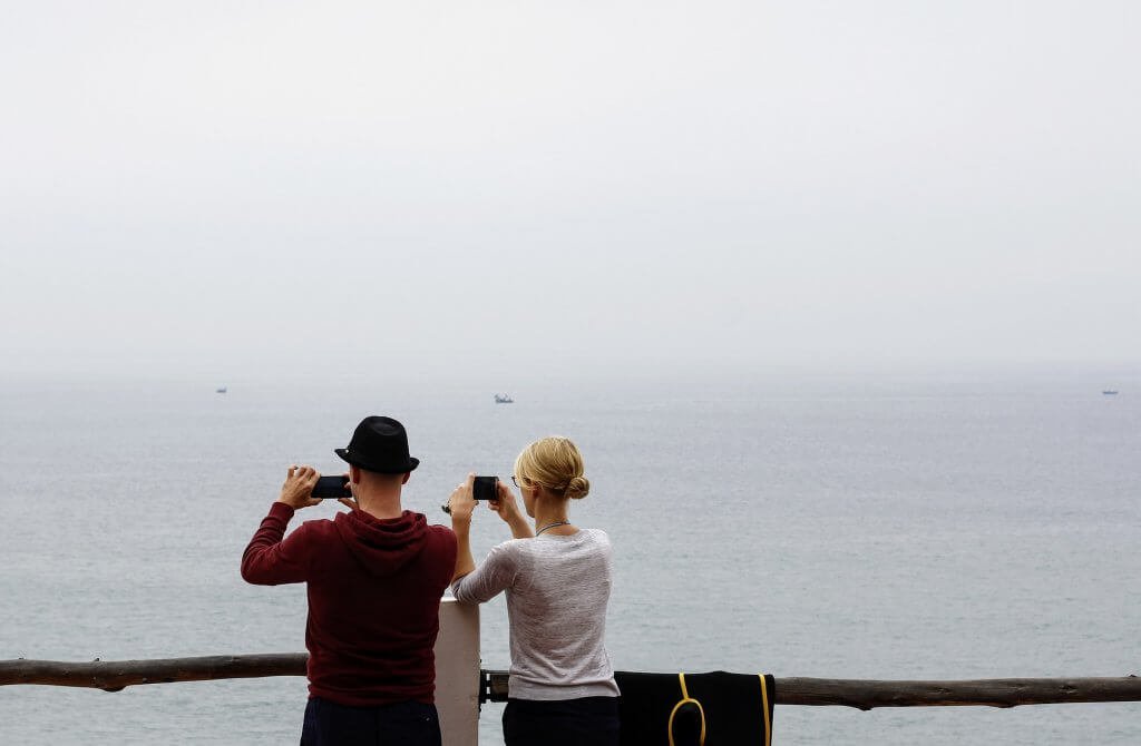 Casal tirando fotos do mar