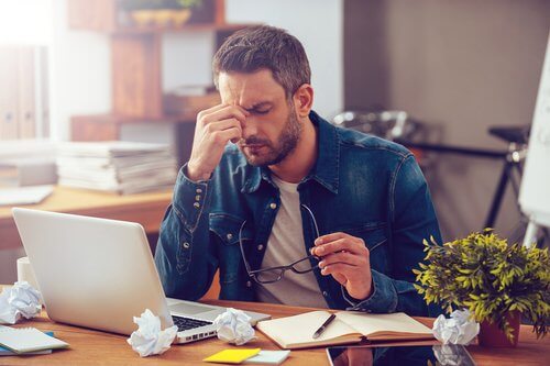 Homem cansado e com dor de cabeça