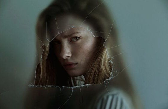 Menina atrás de vidro quebrado