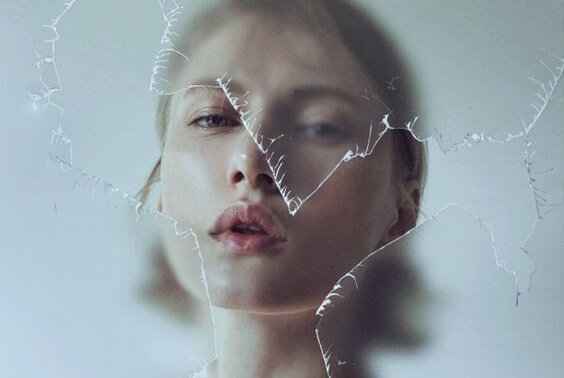 Mulher diante de vidro quebrado