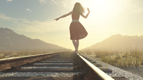 Mulher andando em trilho de trem