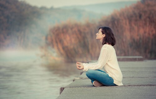 Mulher meditando para afastar névoa mental