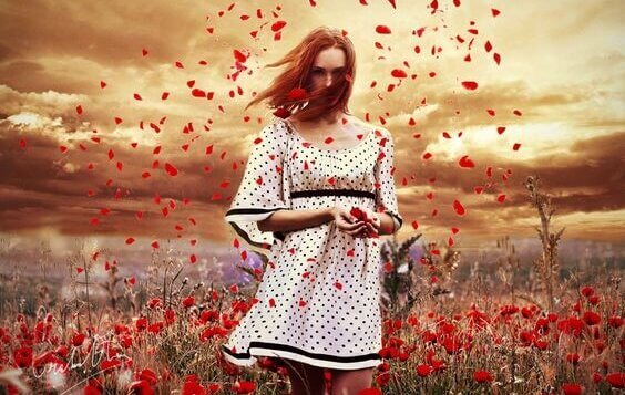 Mulher em campo de flores vermelhas
