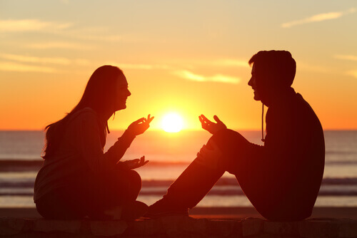 Casal conversando diante do por do sol