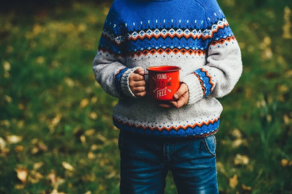 Criança segurando uma caneca