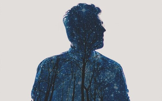 Corpo de homem com floresta e céu estrelado