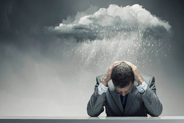 Homem sob uma nuvem de chuva