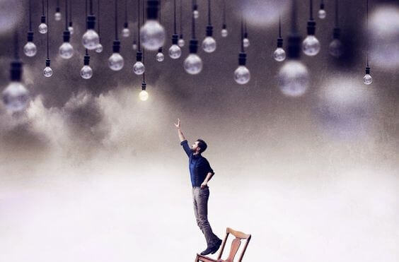 Homem tentando alcançar lâmpada acesa