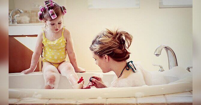Mãe na banheira com sua filha