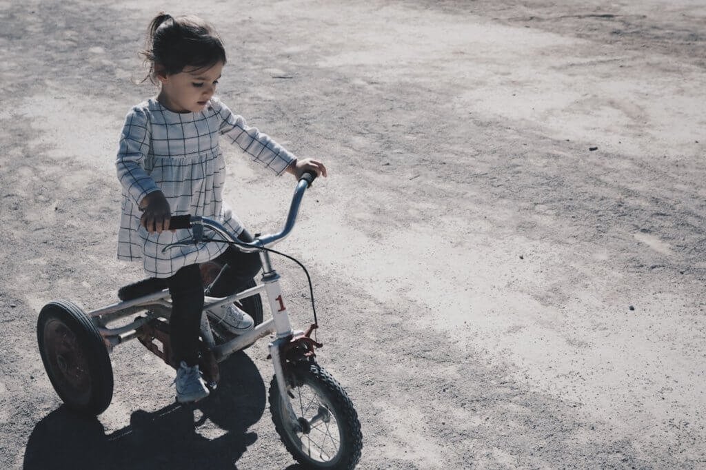 Menina andando de triciclo