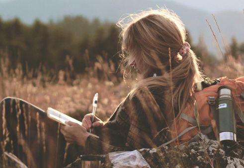 Menina escrevendo carta no campo