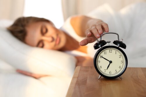 Mulher desligando despertador