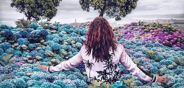 Mulher caminhando em jardim de flores