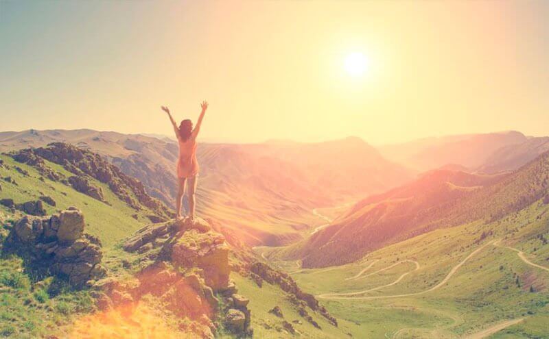 Mulher feliz por chegar ao topo da montanha
