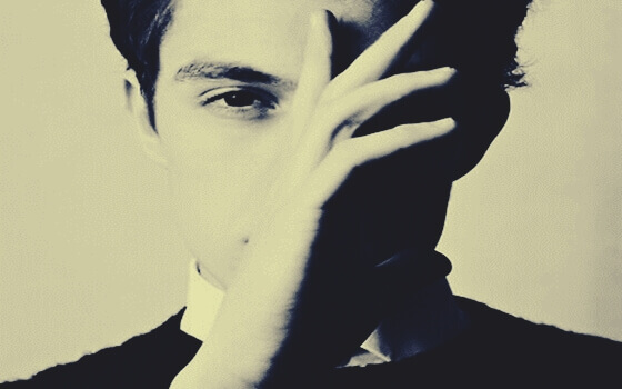 Homem cobrindo um lado de seu rosto