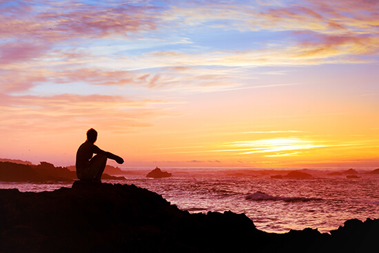 Homem observando o por do sol