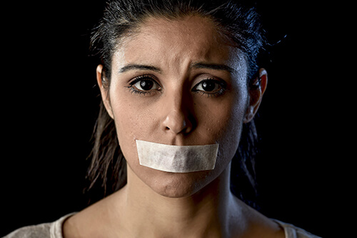 Mulher com esparadrapo na boca