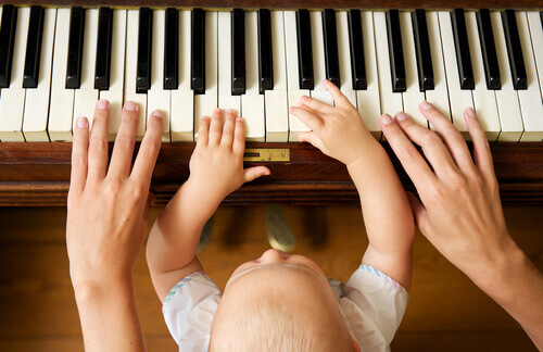 Pai tocando piano com seu bebê