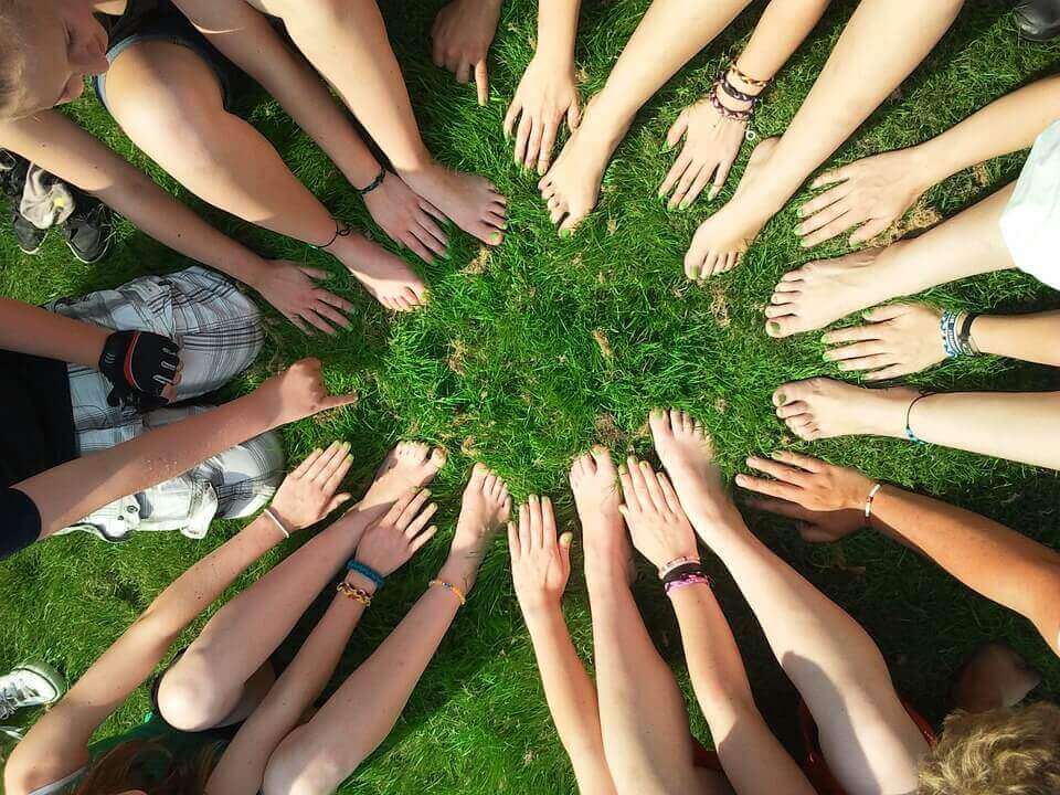 Pessoas com pés e mãos unidos
