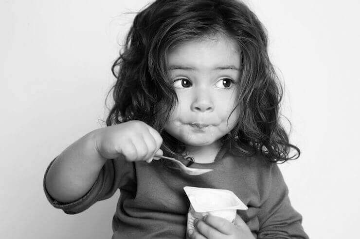 Menina tomando um iogurte