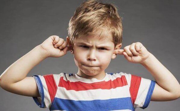 Menino tampando seus ouvidos