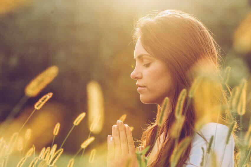 Mulher meditando com os olhos fechados