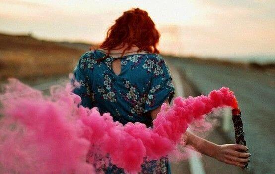 Mulher segurando fumaça cor-de-rosa